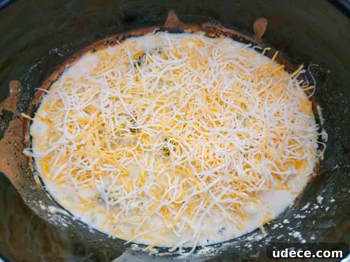 Slow-Cooker Chicken Poppy Seed Casserole Recipe 7 Crockpot Chicken Poppy Seed Casserole topped with cheese in a slow cooker.