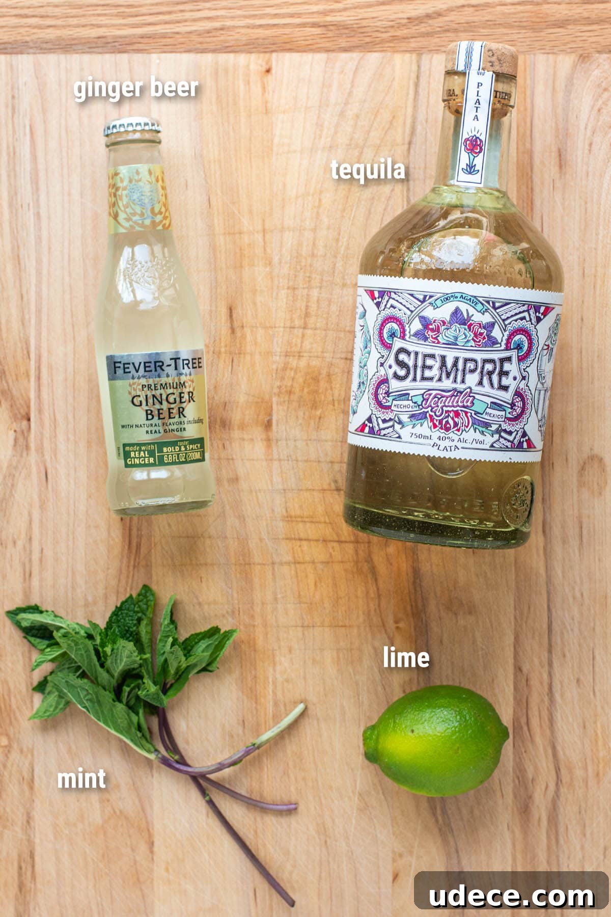 Tequila Mule Cocktail Recipe: How to Make a Classic Mexican Mule 3 Tequila Mule cocktail ingredients laid out on a wooden cutting board.