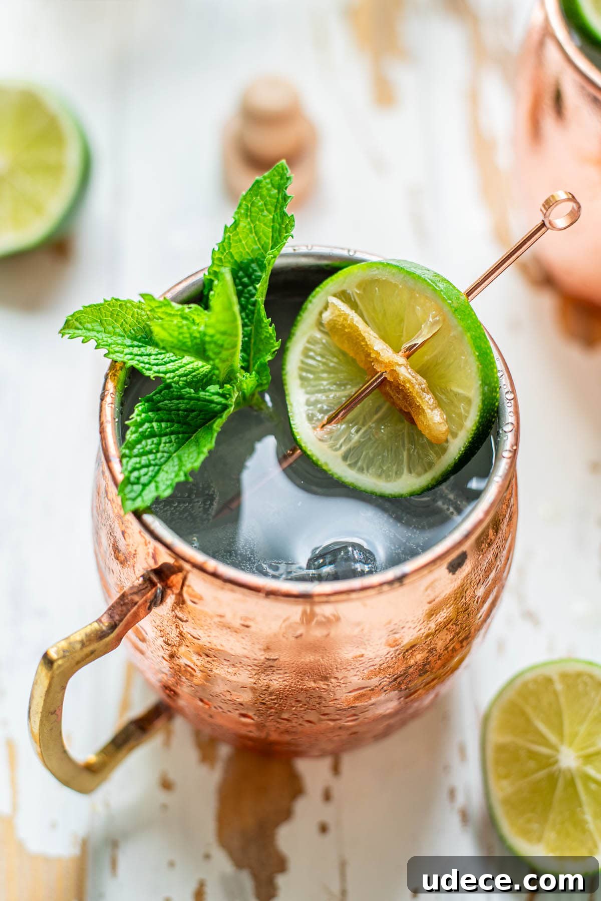 Tequila Mule Cocktail Recipe: How to Make a Classic Mexican Mule 4 A Tequila Mule served in a copper mug garnished with mint leaves, a lime wheel, and candied ginger.