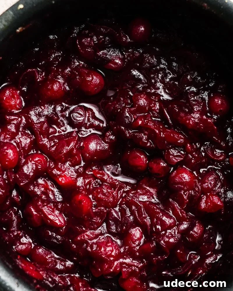 Mandarin Orange Cranberry Sauce Recipe — Ready in 20 Minutes 5 simmering cranberry sauce in a small pot with orange juice and zest