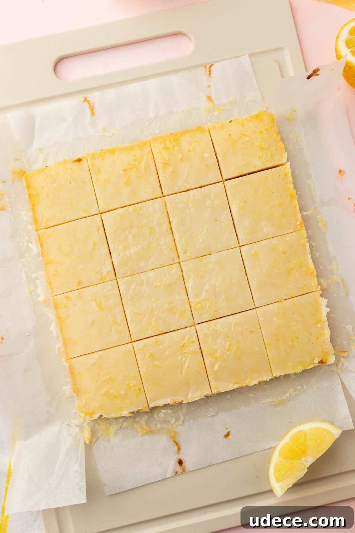 Gluten-Free Lemon Brownies Recipe — Zesty Citrus Brownie Bars 12 Lemon brownies on a cutting board that have been cut into 16 equal pieces.