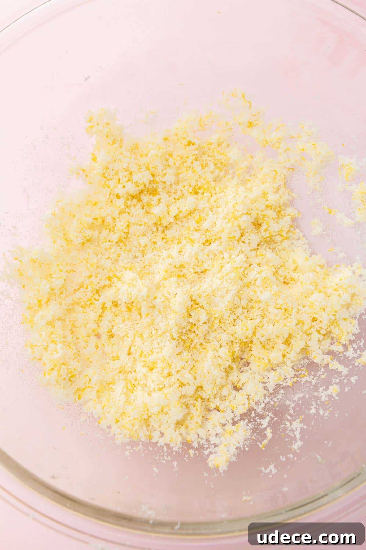 Gluten-Free Lemon Brownies Recipe — Zesty Citrus Brownie Bars 4 A glass mixing bowl with a granulated sugar and lemon zest mixture that has been mixed together.