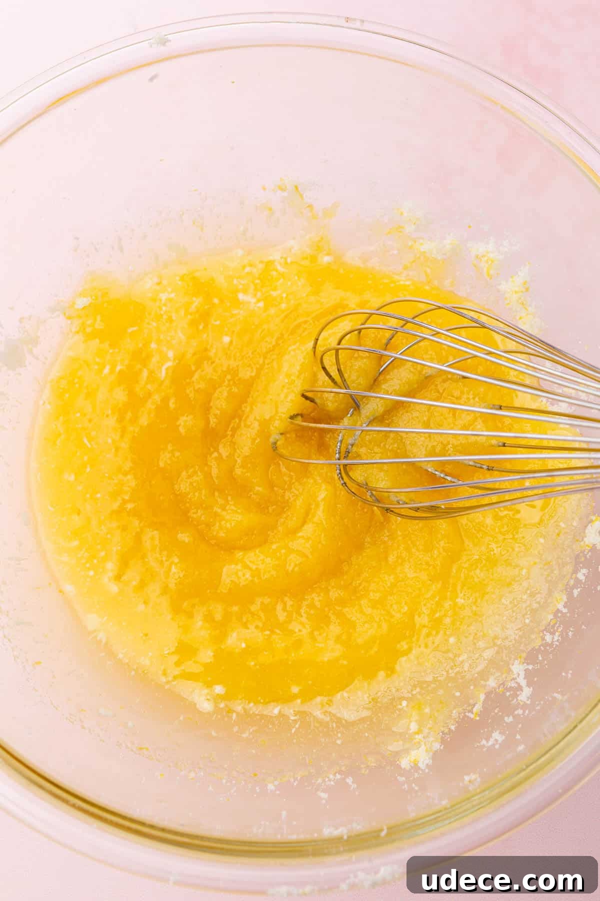 Gluten-Free Lemon Brownies Recipe — Zesty Citrus Brownie Bars 5 A glass mixing bowl with melted butter and granulated sugar that is being whisked together.