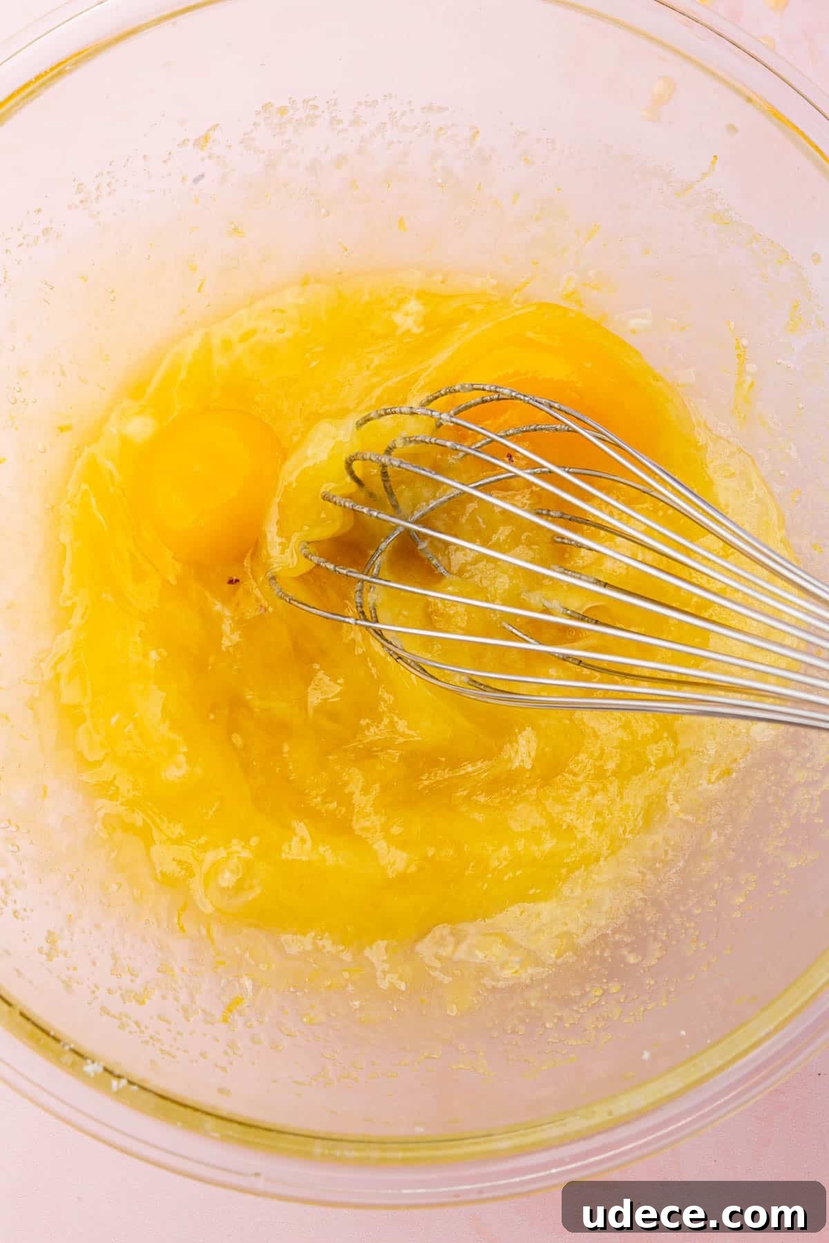 Gluten-Free Lemon Brownies Recipe — Zesty Citrus Brownie Bars 6 A glass mixing bowl with a melted butter, lemon juice and egg mixture that is been whisked.