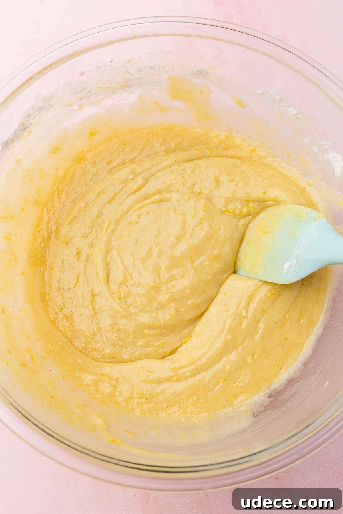 Gluten-Free Lemon Brownies Recipe — Zesty Citrus Brownie Bars 8 A glass mixing bowl of gluten-free lemon brownie batter with a blue spatula.