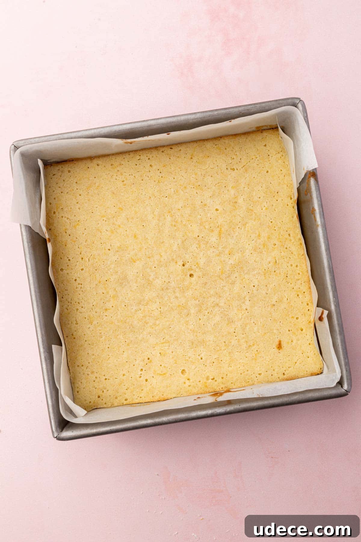 Gluten-Free Lemon Brownies Recipe — Zesty Citrus Brownie Bars 9 A square metal baking dish with baked lemon brownies in it.