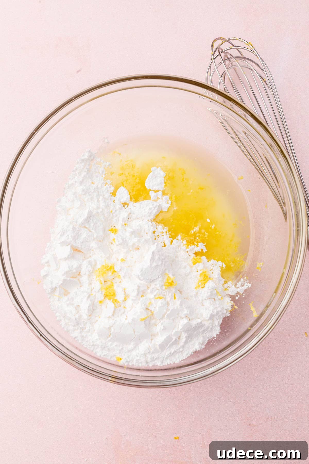 Gluten-Free Lemon Brownies Recipe — Zesty Citrus Brownie Bars 10 A glass mixing bowl with powdered sugar, lemon juice and lemon zest before mixing together.