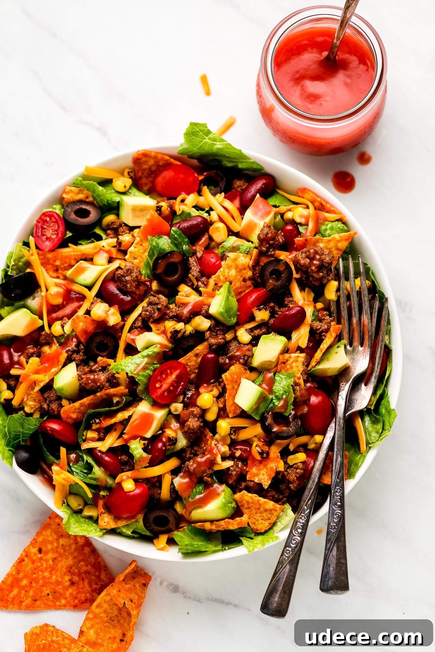 Taco Salad dizzled with Catalina dressing and a jar of it to the side.