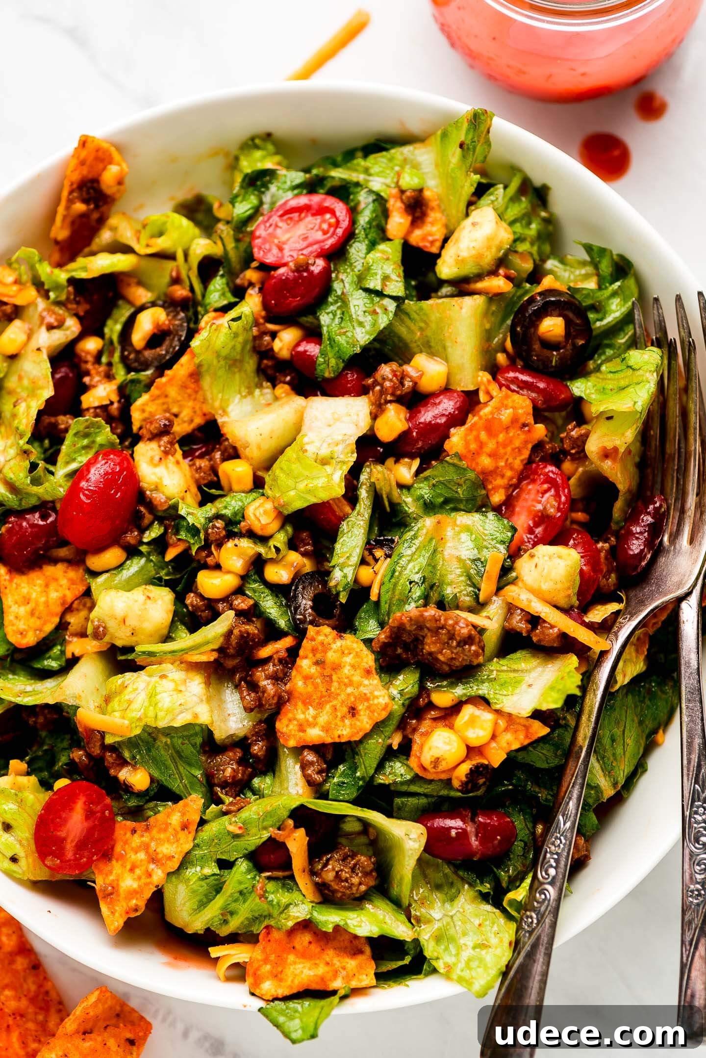Dorito Taco Salad in a bowl tossed in dressing.