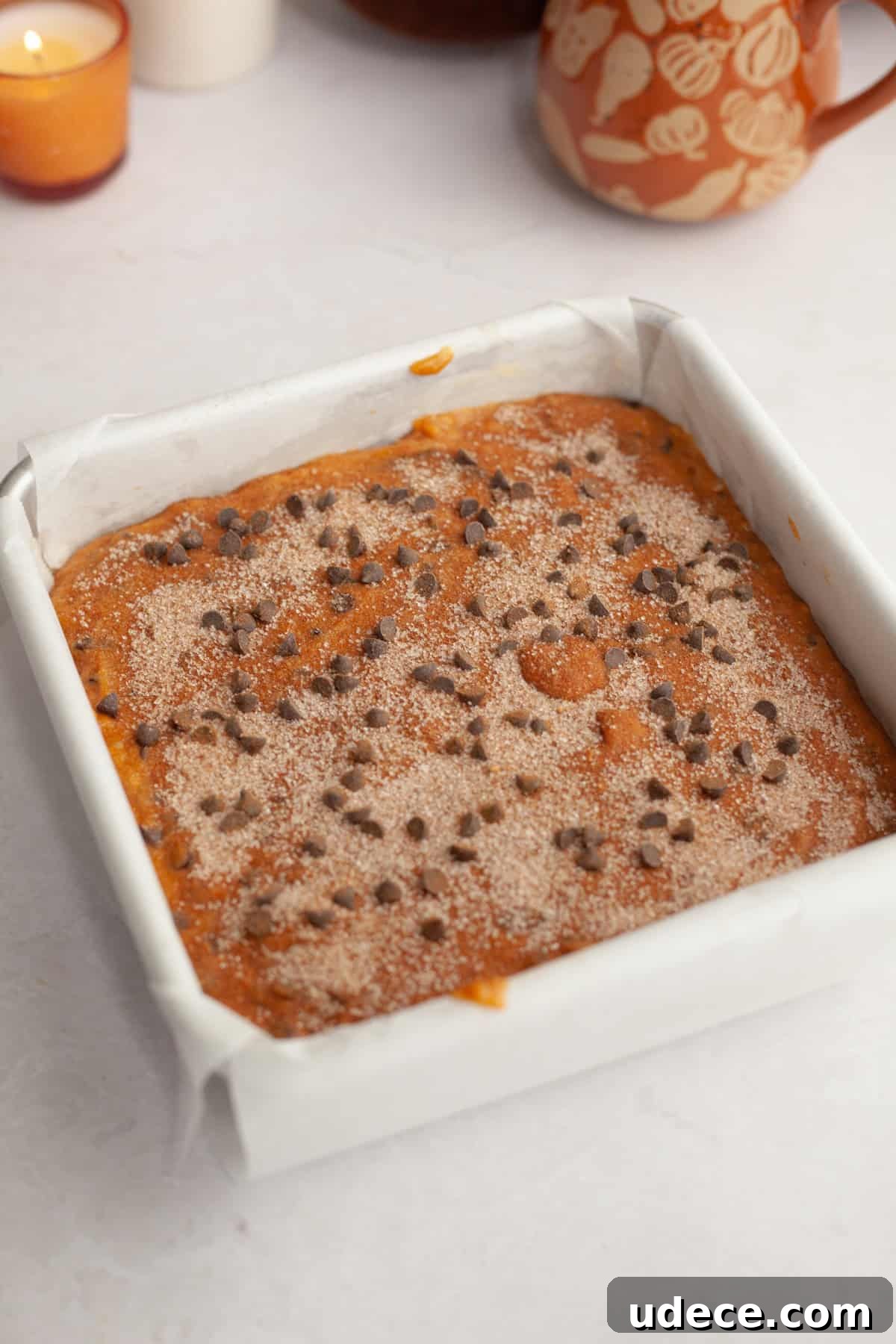 Unbaked pumpkin chocolate chip cake in a square pan.