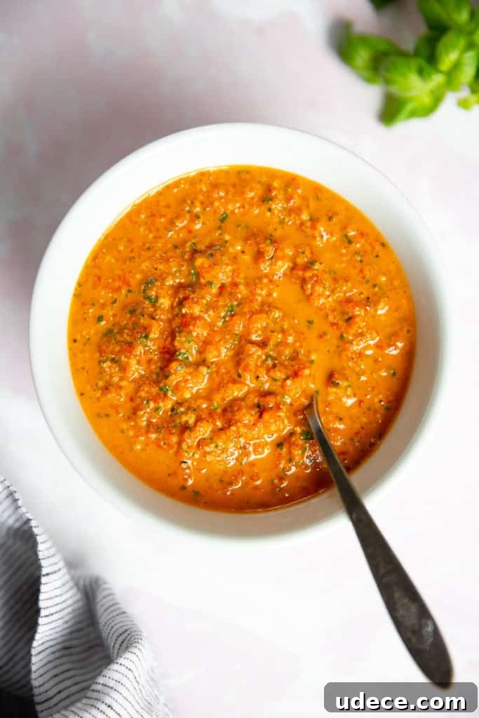 Roasted Red Pepper Pesto Pasta — Gluten-Free Recipe 2 Roasted red pepper pesto in a bowl with a spoon.