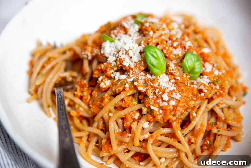 Roasted Red Pepper Pesto Pasta — Gluten-Free Recipe 11 Red pepper pesto pasta in a bowl with a fork.