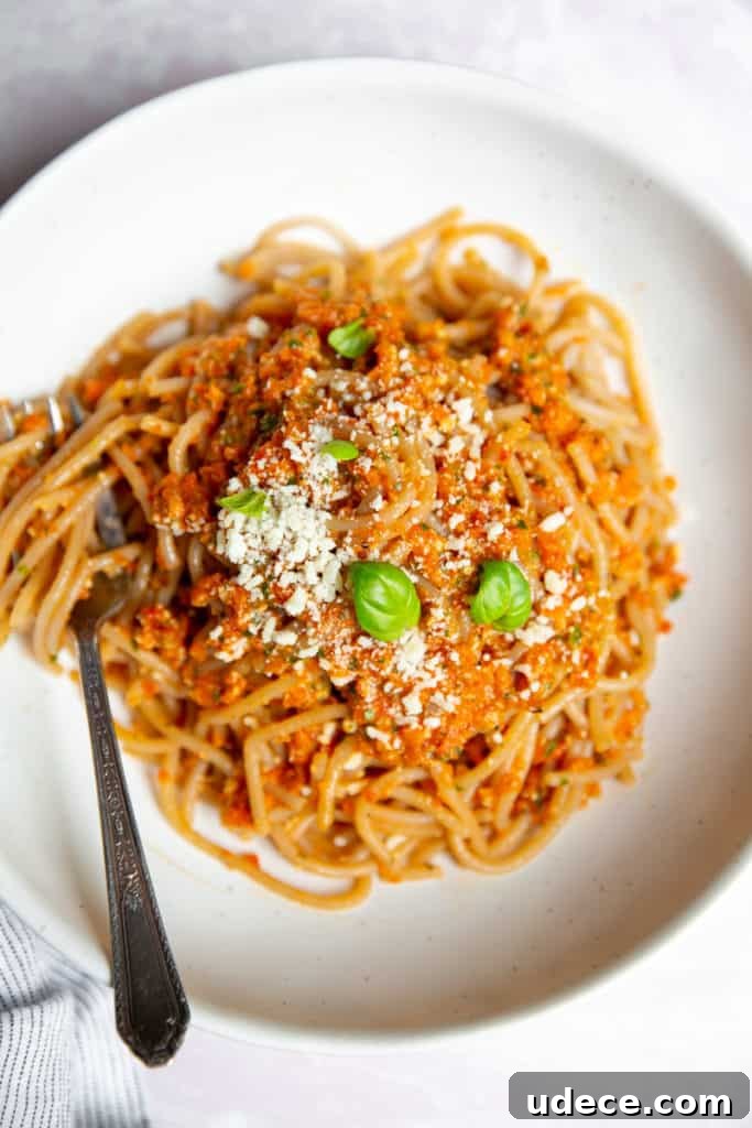 Roasted Red Pepper Pesto Pasta — Gluten-Free Recipe 10 Roasted red pepper pesto tossed with spaghetti in a bowl with a fork.