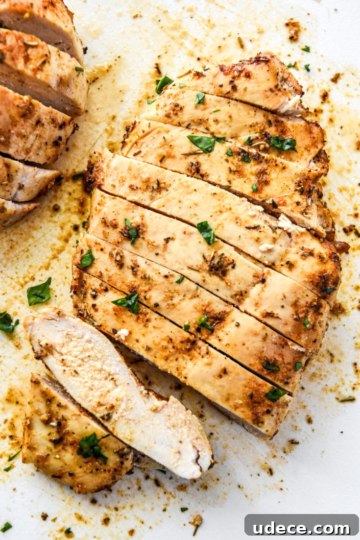 juicy air fryer chicken breasts cut into slices on a cutting board.