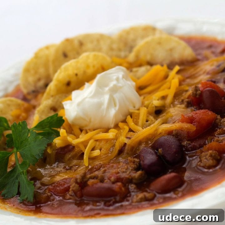 Week 33 Meal Plan for Group 1: Daily Dinner & Prep Guide 6 White bowl filled with soup of beans, tomatoes, and beef, topped with shredded cheddar cheese, tortilla chips, and sour cream, garnished with cilantro.