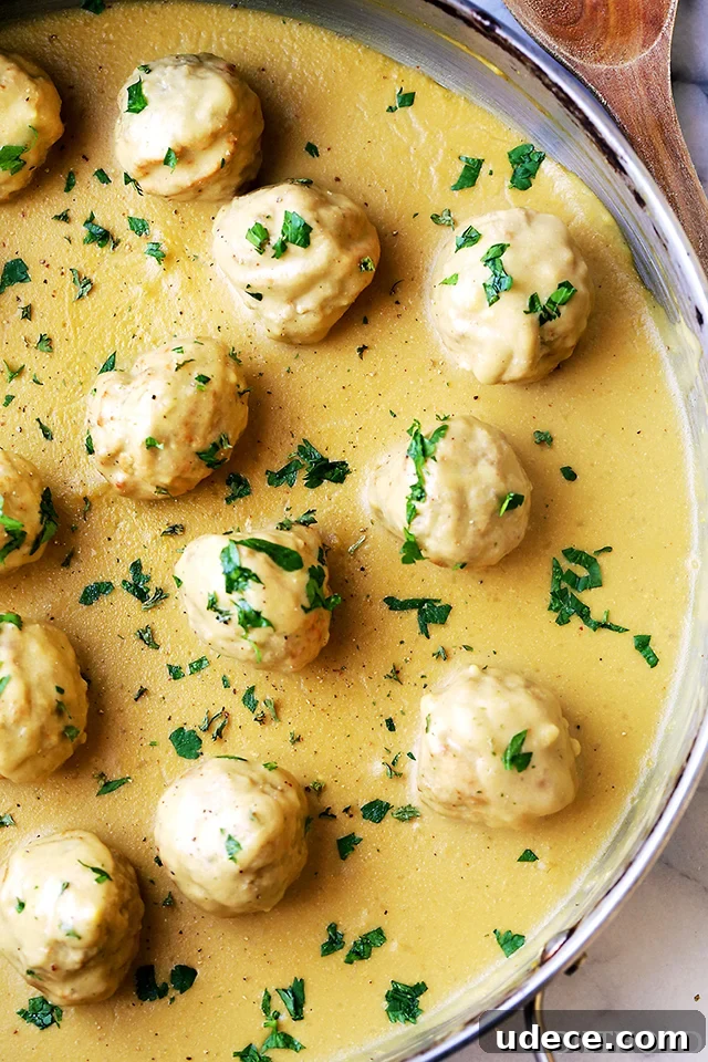 This baked turkey Swedish meatballs recipe with homemade mustard gravy is an easy twist on a classic comfort food. Creamy gravy in the pan with turkey meatballs.