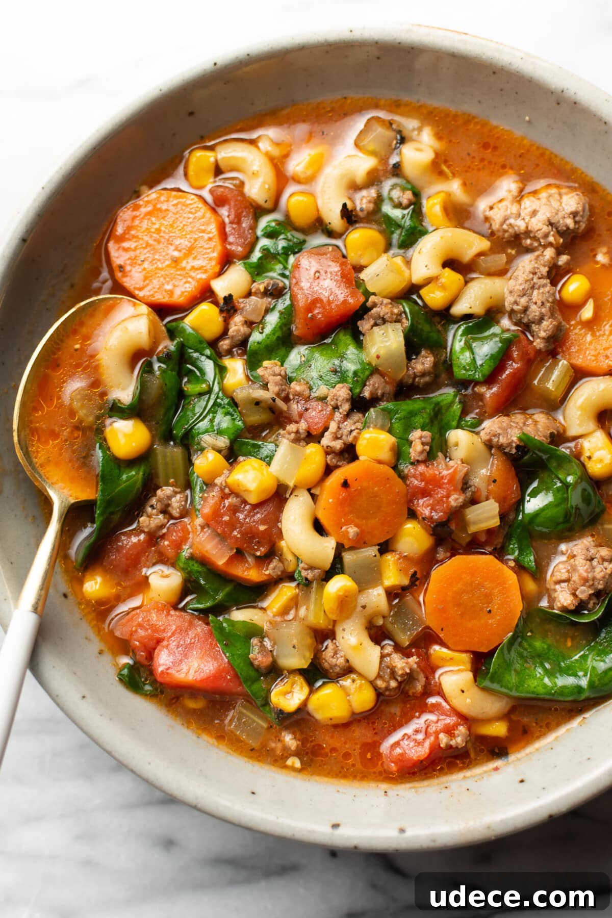 Comforting Macaroni Soup Recipe with Savory Broth and Veggies 2 a bowl of ground beef macaroni soup with a spoon