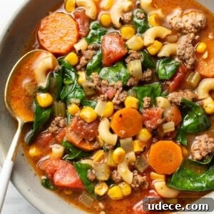 Comforting Macaroni Soup Recipe with Savory Broth and Veggies 8 a bowl of ground beef macaroni soup with a spoon