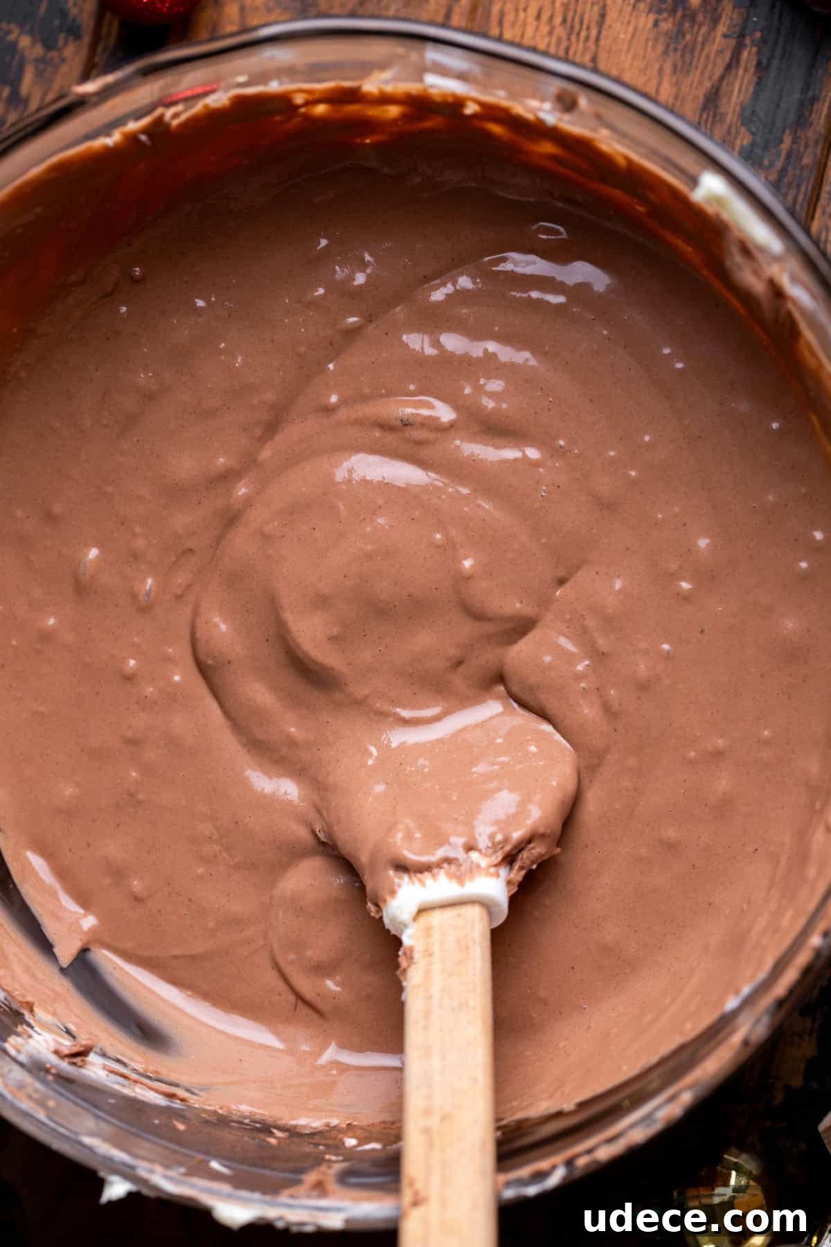 Chocolate cheesecake batter in a glass bowl.
