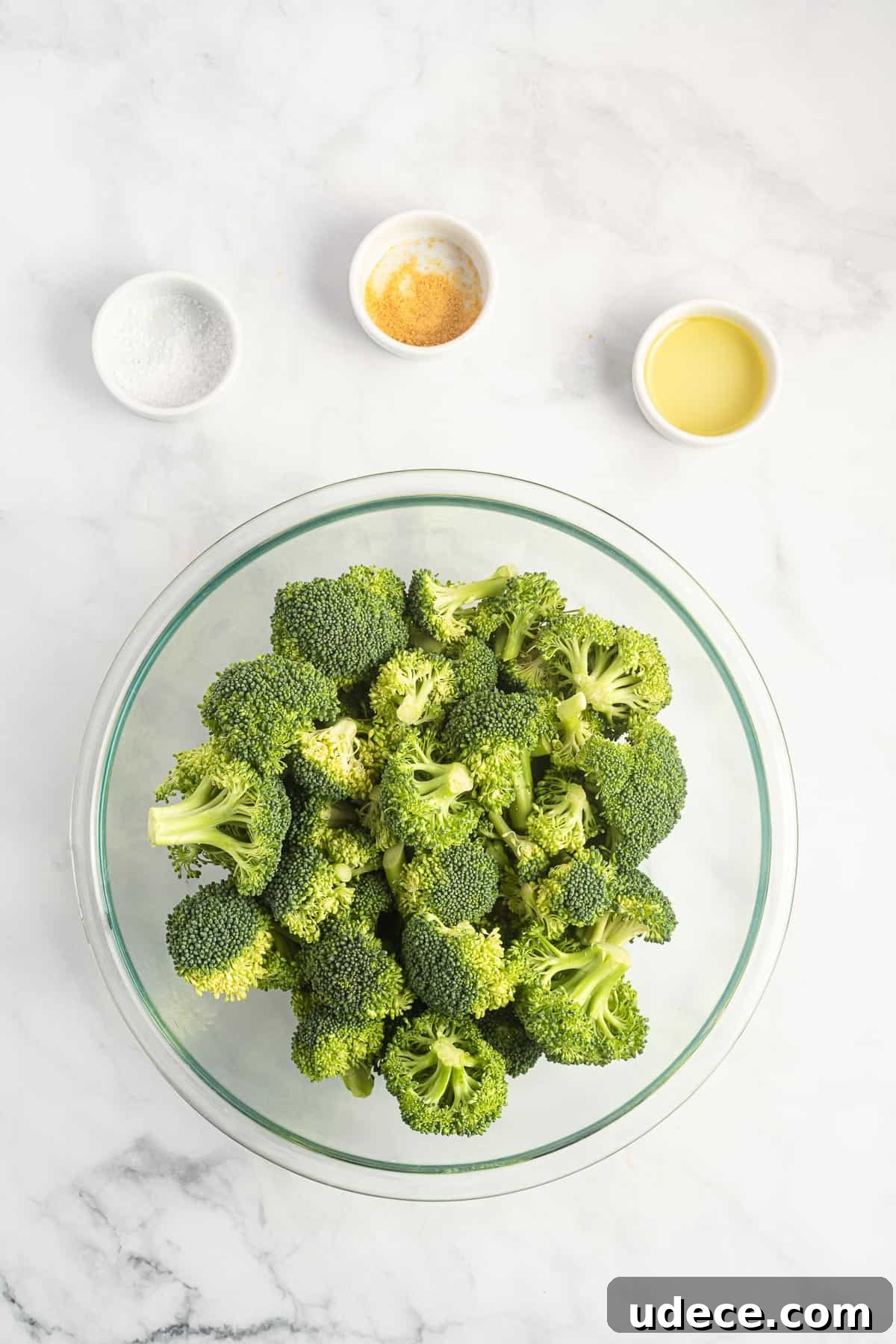 Crispy Air Fryer Broccoli Recipe — Quick Roasted Florets 3 broccoli florets in a bowl surrounded by the spices
