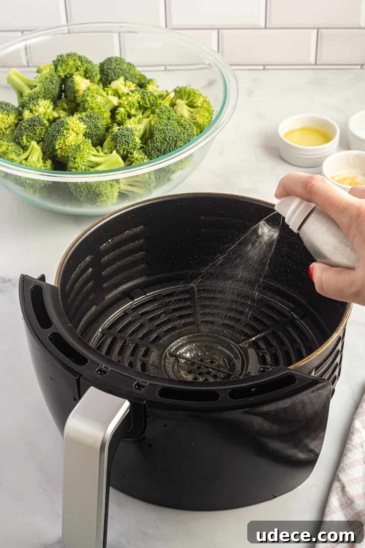 Crispy Air Fryer Broccoli Recipe — Quick Roasted Florets 4 spraying olive oil spray into an air fryer basket