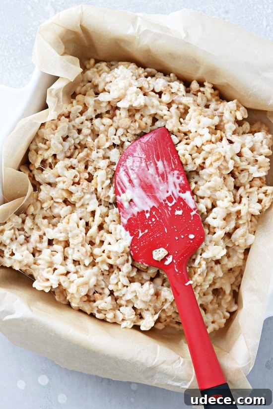Dairy-Free Rice Krispies Treats: Crispy No-Milk Recipe 4 Non Dairy Rice Krispie Treats being pressed into a pan.
