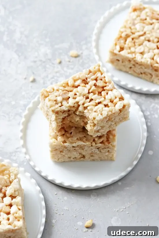 Dairy-Free Rice Krispies Treats: Crispy No-Milk Recipe 6 Coconut Oil Rice Krispie Treats on plates with a bite taken out of one.