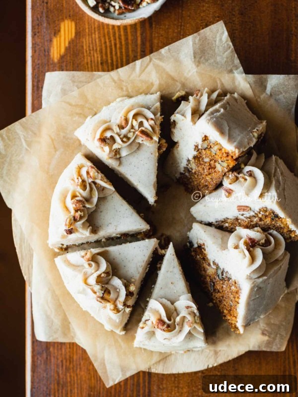 Moist Single-Layer Vanilla Bean Cake Recipe 6 Overhead image of single layer carrot cake frosted on parchment paper and placed on a wood dining room table.