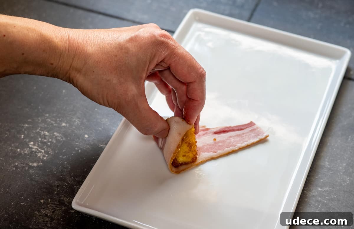 Crispy Bacon-Wrapped Pineapple Bites: Sweet and Savory Appetizer 6 rolling coated pineapple chunk in bacon strip.