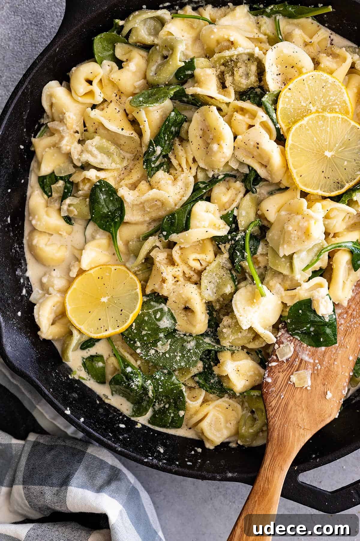 Creamy Lemon Tortellini Recipe with Garlic and Parmesan 2 Overhead view of creamy lemon tortellini in a skillet with wood spatula to the side.