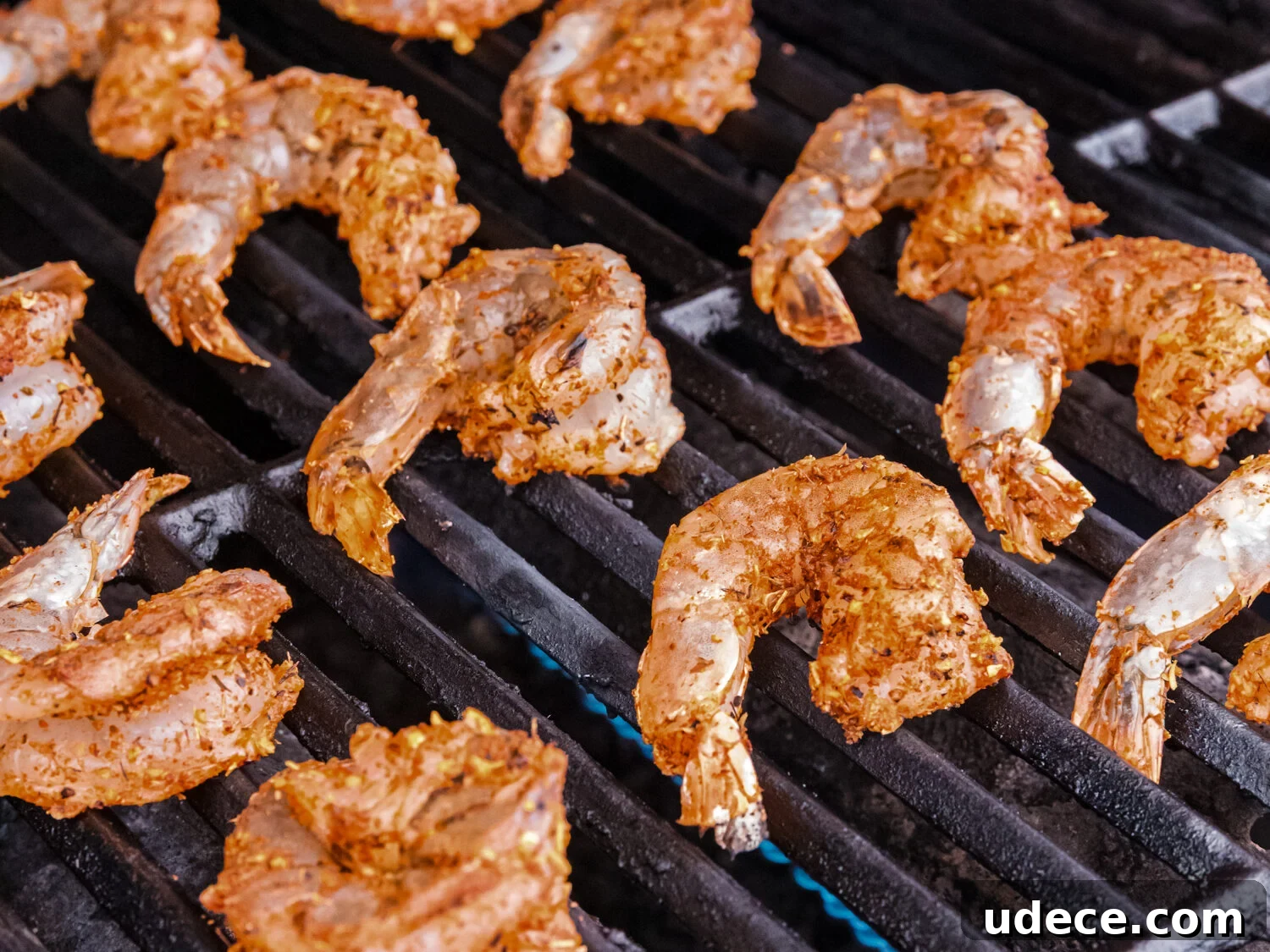 Spicy Cajun Grilled Shrimp Recipe for Quick Weeknight Meals 6 Seasoned shrimp placed directly on a grill with flames underneath, beginning to cook.