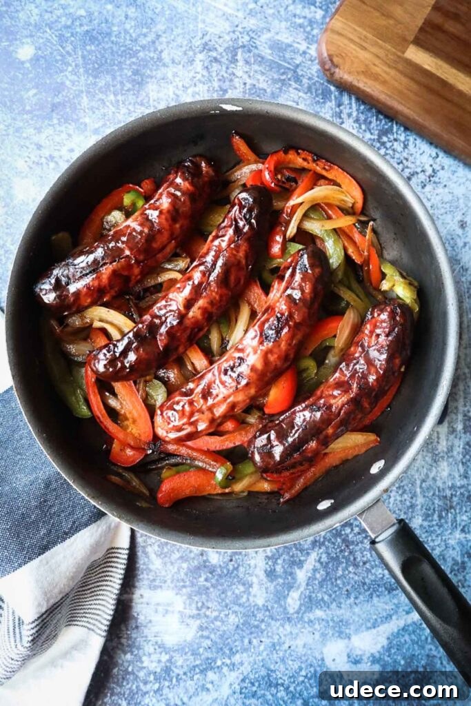 Crispy Air Fryer Chicken Sausage Recipe 5 skillet with pan fried green pepper, red pepper, and onion with four air fryer chicken sausages over top