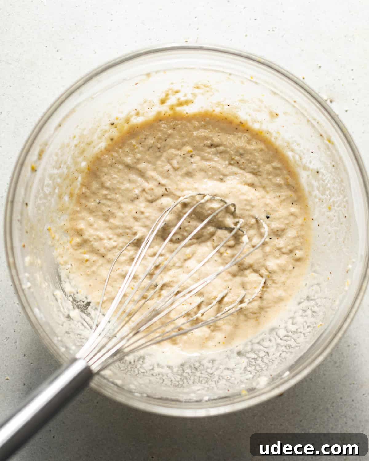 beer batter mixed together in a bowl with a whisk. 