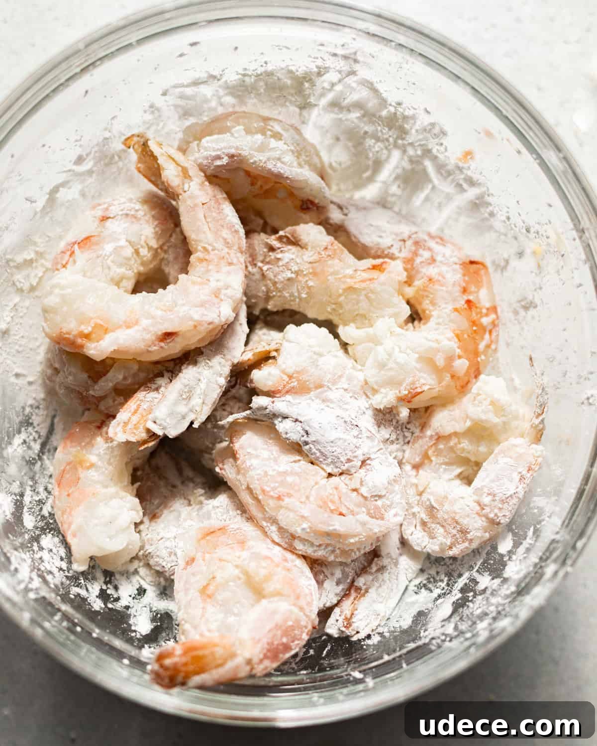 shrimp coated in cornstarch in a bowl. 