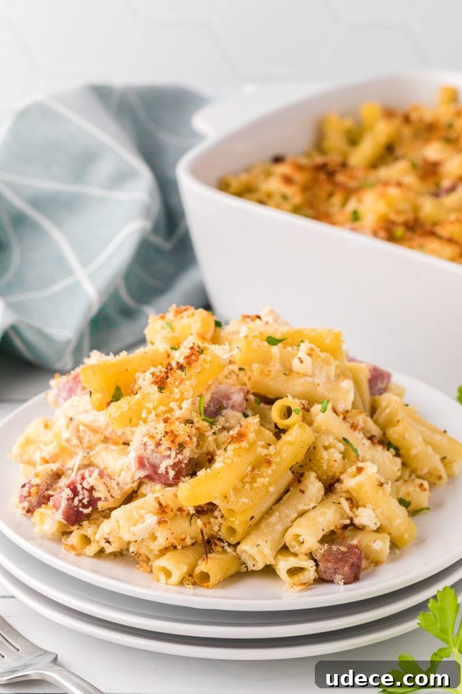 Creamy Chicken Cordon Bleu Pasta Bake 2 Cordon Bleu Casserole on a plate with a white baking dish in the background