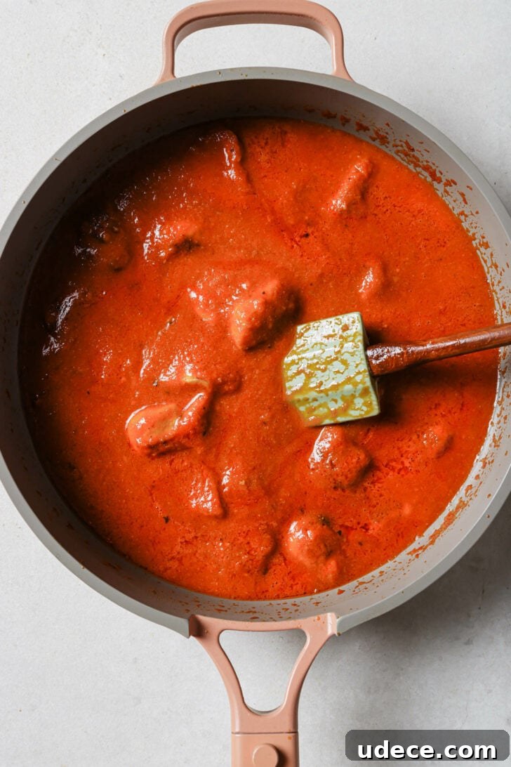 Authentic Butter Chicken Recipe: Tried and Perfected After 20 Tests 30 Cooked chicken added to Butter Chicken sauce in skillet ready to be simmered.