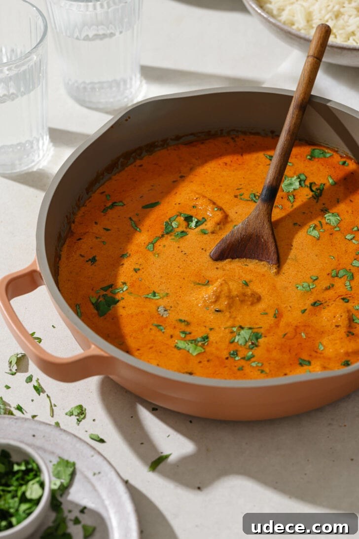 Authentic Butter Chicken Recipe: Tried and Perfected After 20 Tests 34 Butter Chicken in a skillet garnished with cilantro on a dinner table.