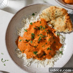 Authentic Butter Chicken Recipe: Tried and Perfected After 20 Tests 39 A bowl of rice topped with Butter Chicken with some naan on the side.