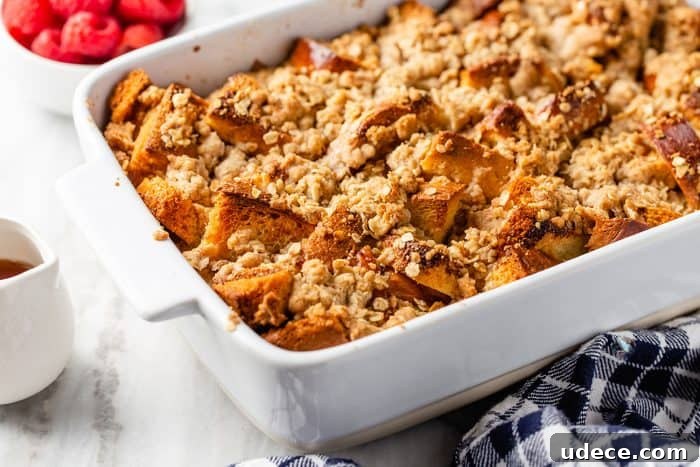 Overnight French Toast Casserole Recipe for Make-Ahead Brunch 13 3/4 view of baked overnight french toast casserole in a white baking dish, set on a blue plaid towel on a marble counter
