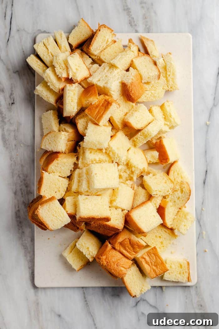 Overnight French Toast Casserole Recipe for Make-Ahead Brunch 4 Brioche bread cubes on a white mat set on a marble countertop