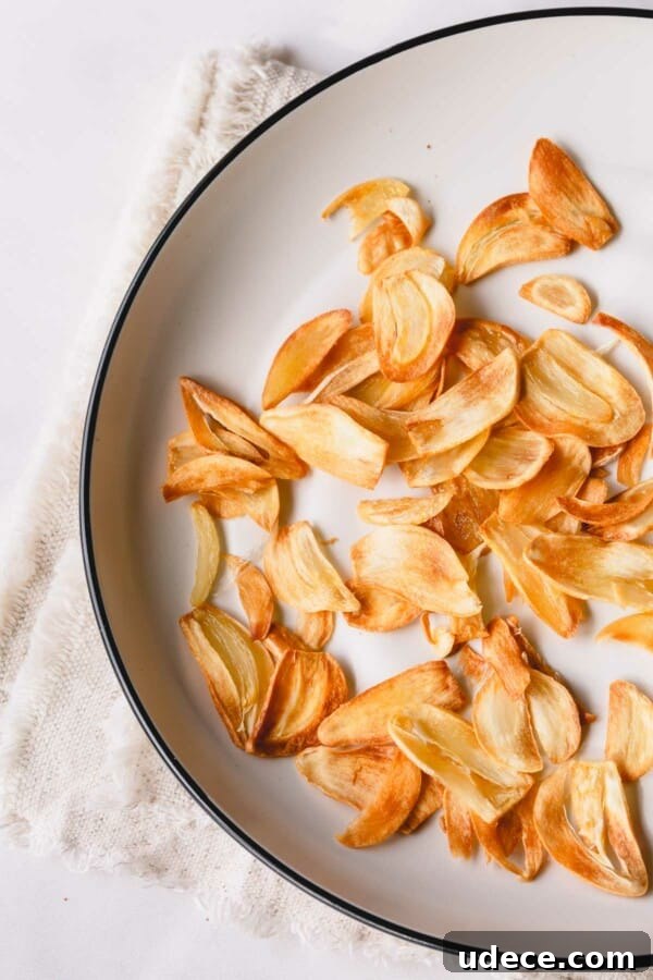 Crispy Garlic Chips Recipe: Homemade Thin Garlic Crisps 6 Golden fried garlic slices on a white plate.