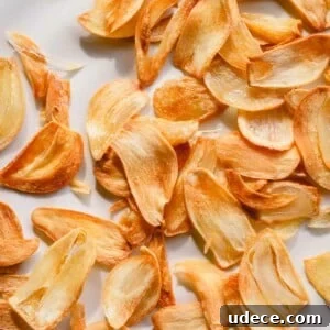 Crispy Garlic Chips Recipe: Homemade Thin Garlic Crisps 7 Golden fried garlic slices on a white plate.