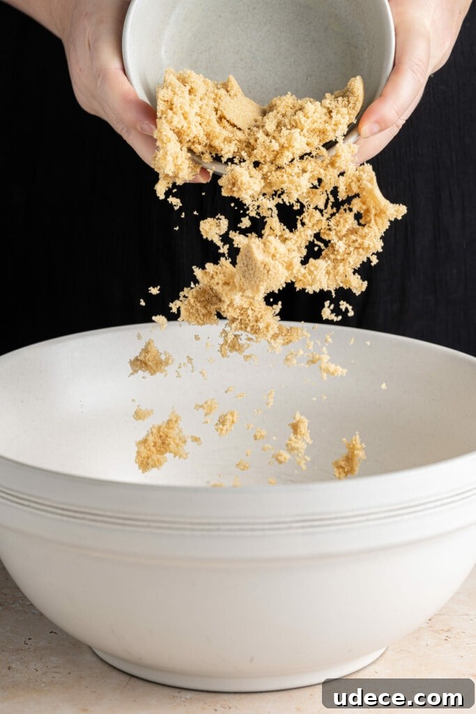 Adding brown sugar to banana bread batter.