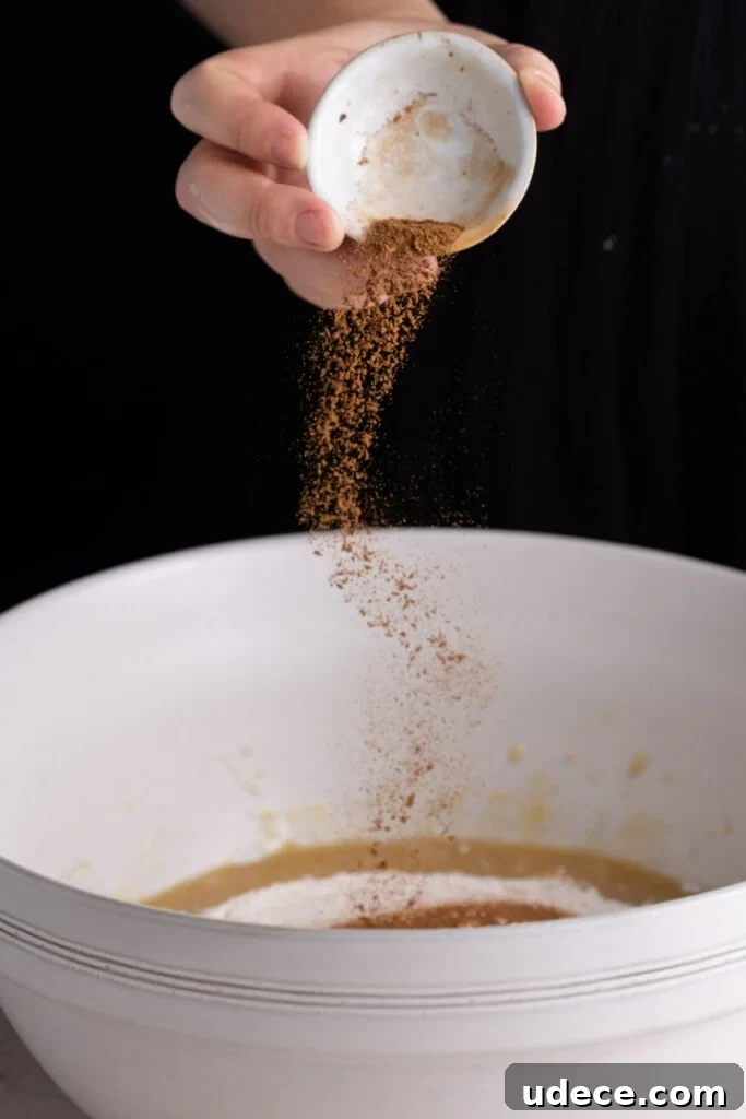 Adding cinnamon to the banana bread batter.