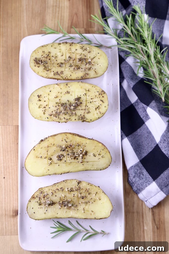 How to make grilled baked potatoes with garlic rosemary butter Garlic Butter Potatoes on a platter with fresh rosemary and a plaid napkin