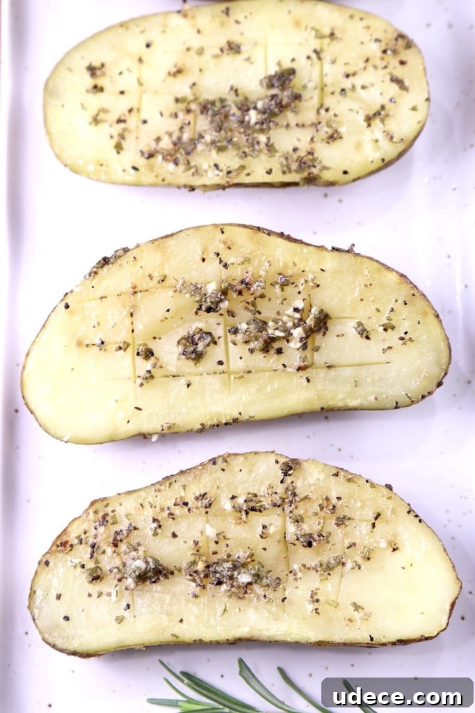 how to grill potatoes in foil packets with garlic rosemary butter Garlic Butter Baked Potato Halves on a white platter