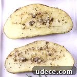 Garlic Butter Baked Potatoes Recipe for Crispy, Flavorful Results 3 Garlic Butter Baked Potatoes with herbs, 2 halves on a white plate