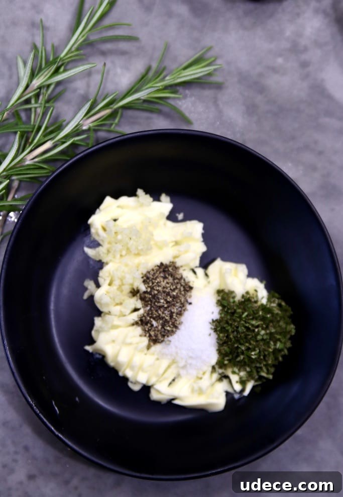 How to make garlic butter for baked potatoes Bowl with butter, rosemary, garlic, salt and pepper