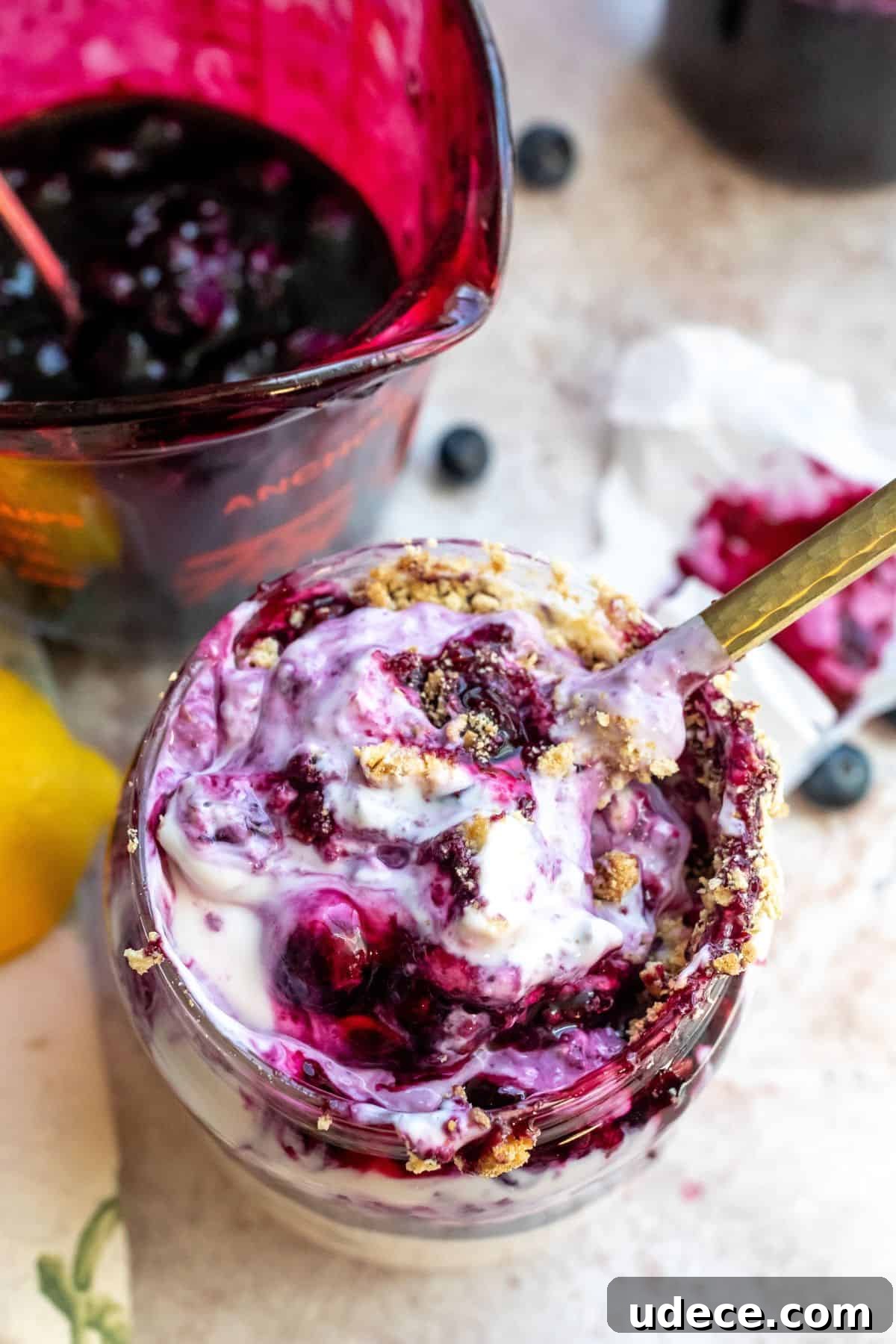 Homemade Blueberry Syrup Recipe for Pancakes and Desserts 5 An image of blueberry syrup swirled into vanilla ice cream.