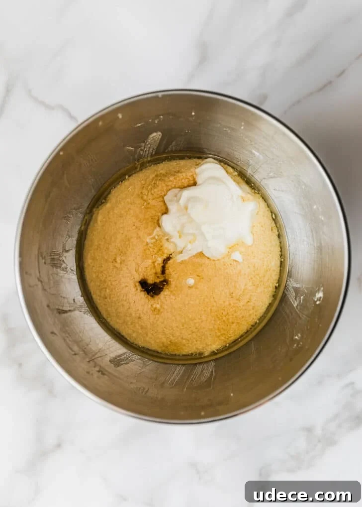 High-Altitude Yellow Cupcakes with Rich Chocolate Buttercream 6 A silver bowl of butter, sugar, eggs, and sour cream on a marble table.
